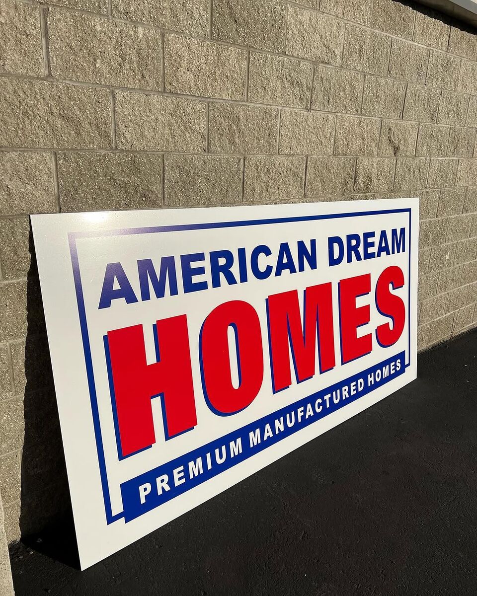 Four foot by eight foot American Dream Homes panel sign in red, white and blue reading Premium Manufactured Homes