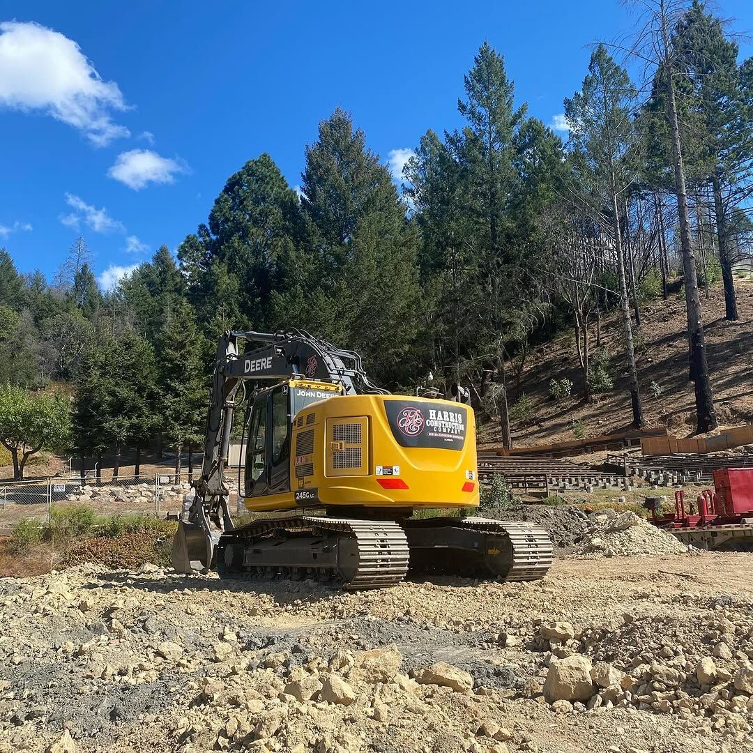 Yellow tracked excavator carrying Harris Construction graphics, parked on a graded site