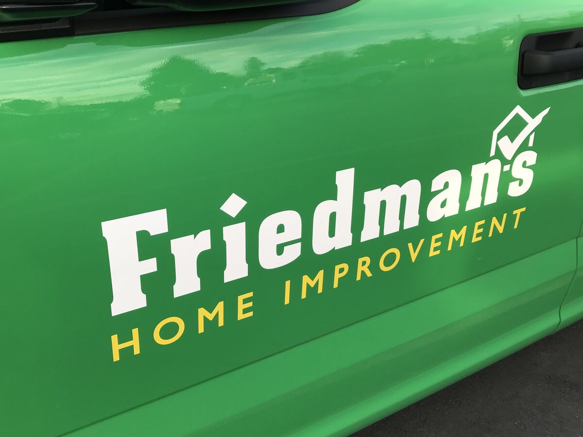 Close view of a green truck door carrying the Friedman's Home Improvement wordmark in white with a yellow subline